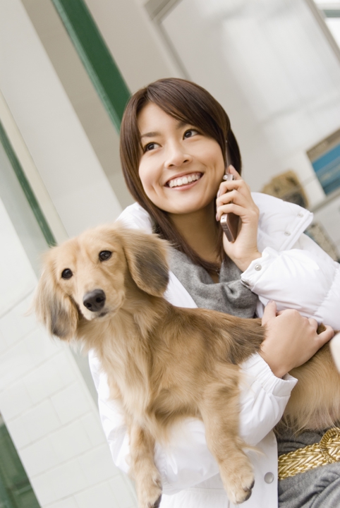 犬を抱いて電話する人