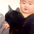 ママが赤ちゃんを抱っこしていると、必ず黒猫がやってきて…あまりにも尊い…