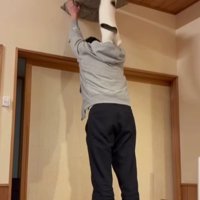 座布団を掲げる飼い主と猫