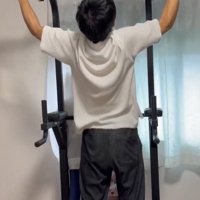 猫が乗っている懸垂の器械で懸垂をする飼い主