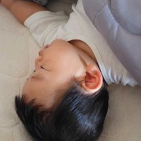 布団の中で眠る赤ちゃん