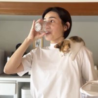 コップに入った水を飲む女性