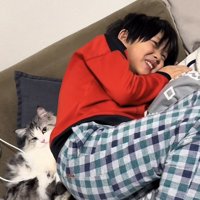 ソファに寝転がるお兄ちゃんとマンチカン