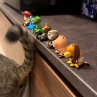 しっぽでフィギュアを触っている猫