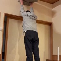 座布団を掲げる飼い主と猫