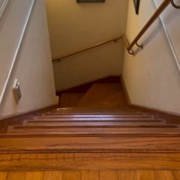 階段下に向かって「おいで」と言う飼い主