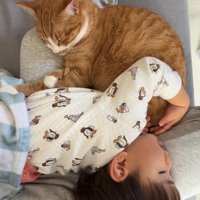 飼い主の膝の上で寝ている猫と子供