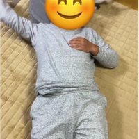 仰向けで寝ている人と猫じゃらしを追いかけている猫
