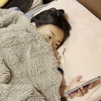 ベッドに寝ている子どもと猫