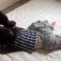 倒れる真似をしている女の子と猫