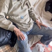 おじいちゃんの前に座る猫