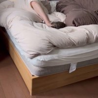 ベッドで寝ている女性と赤ちゃんと猫