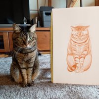 絵の隣に座る猫