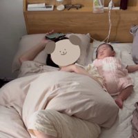 ベッドで寝ている女性と赤ちゃん