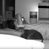 猫と寝転がっている飼い主