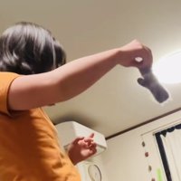 三毛猫に手袋を振って見せる娘さん