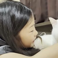 ベッドの上に寝転ぶ子どもと猫