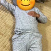 仰向けで寝ている人と猫じゃらしを追いかけている猫