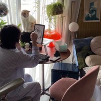 猫を見ながらタブレットにイラストを描く飼い主