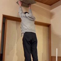 座布団を掲げる飼い主と猫