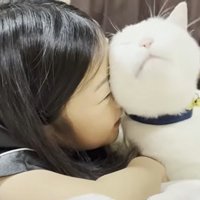 ベッドの上に寝転ぶ子どもと猫
