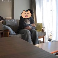 ソファに座って猫を抱っこしている男性（右に傾き）%ちゃぴちゃんが！