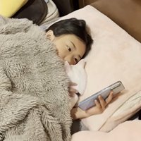 ベッドに寝ている子どもと猫
