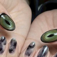 緑色のベースカラーに黒い線が入ったネイルの柄