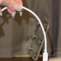 スマホのコードを指で摘まむ飼い主