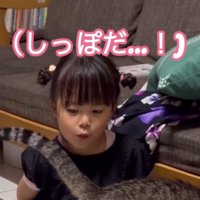 目の前にある猫のしっぽを見つめる女の子