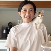 笑顔でカメラを見つめる女性と猫