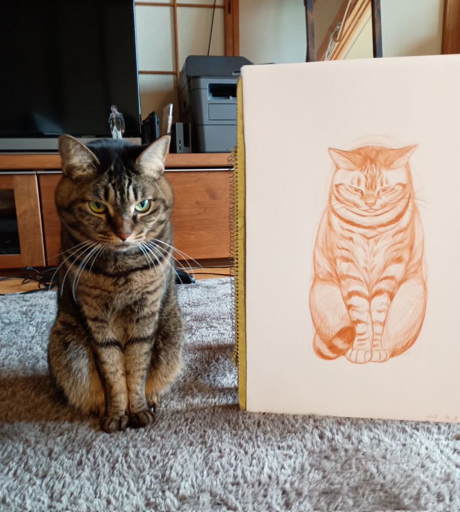 絵の隣に座る猫