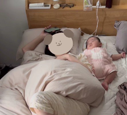 ベッドで寝ている女性と赤ちゃん