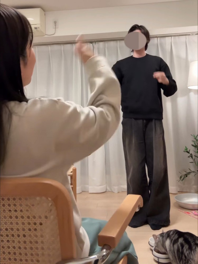 立っている人とごはんを食べる猫