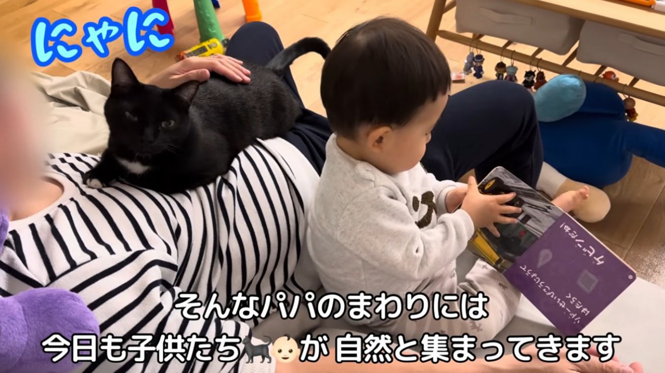 猫を抱いて子供の世話をする人