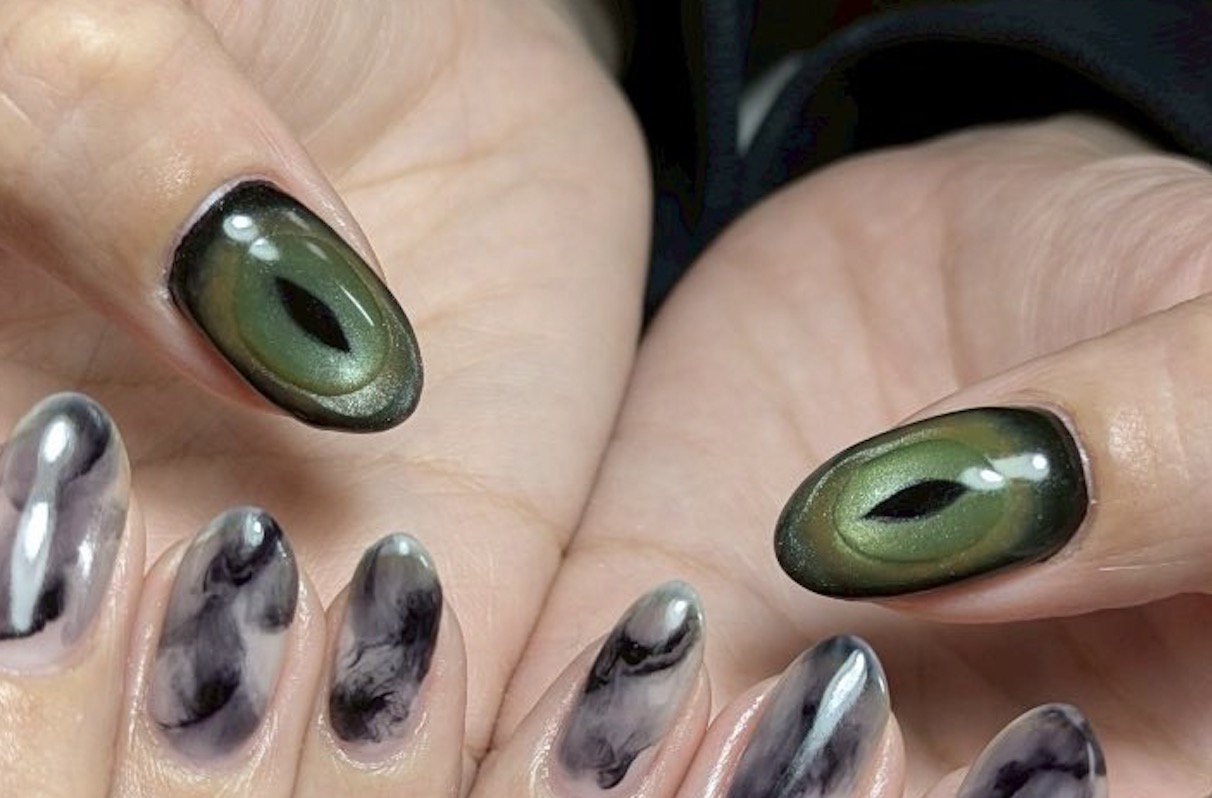 緑色のベースカラーに黒い線が入ったネイルの柄