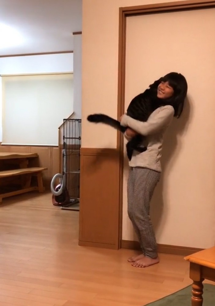 笑顔で猫を抱っこする女の子