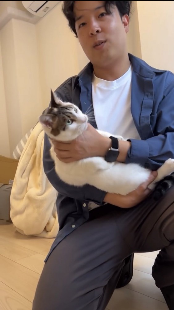 猫を抱っこする男性