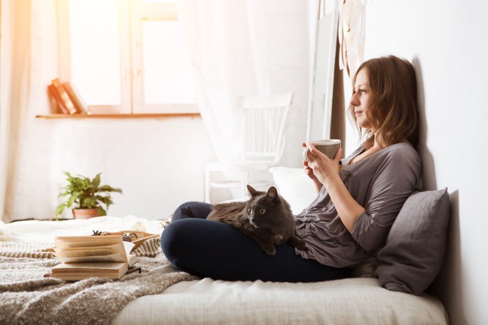 猫を膝に乗せてくつろぐ女性