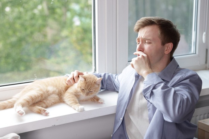 猫とたばこを吸う男性