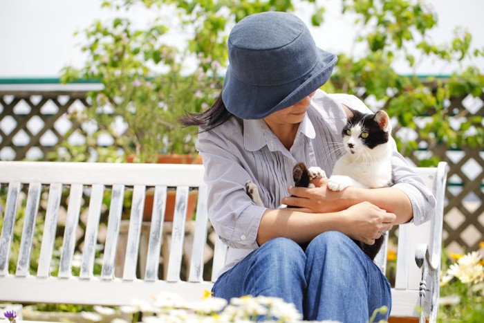 ベンチでくつろぐ女性と猫