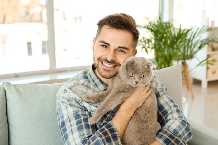 男性に抱かれる猫