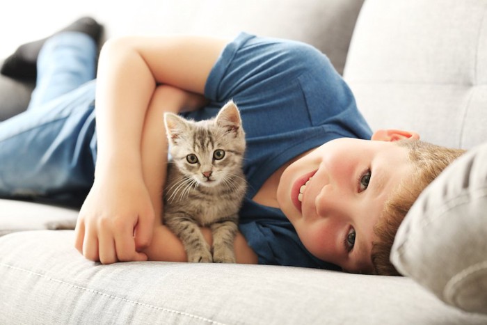 ソファーでくつろぐ男の子と子猫