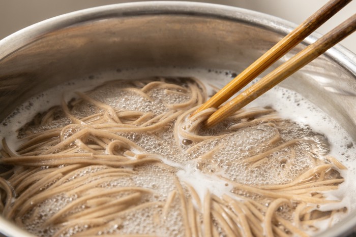 鍋で蕎麦を茹でている様子