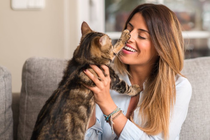 「やめろ」の猫パンチをされる女性