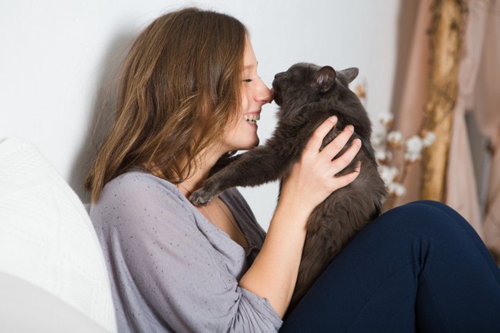 女性の鼻を舐める猫