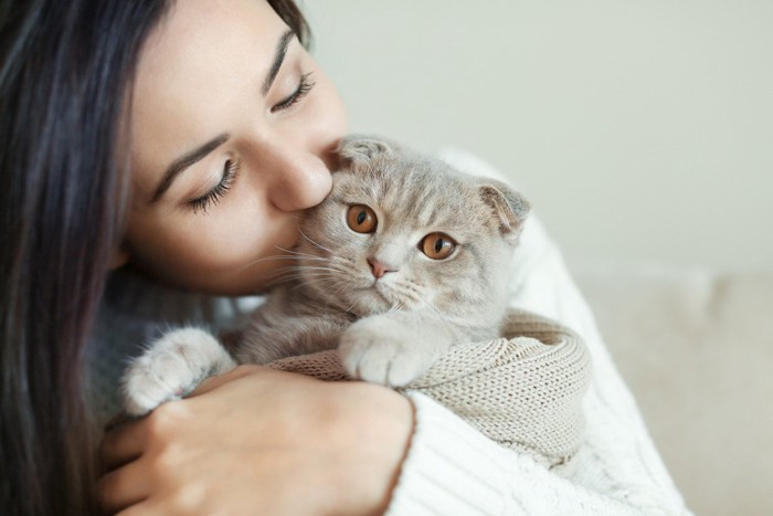 飼い主に抱っこされる猫