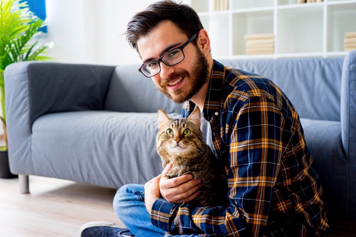 ともに笑顔の猫とヒゲ男性