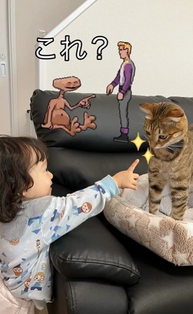 ソファに立っている猫と猫を指さしている子ども