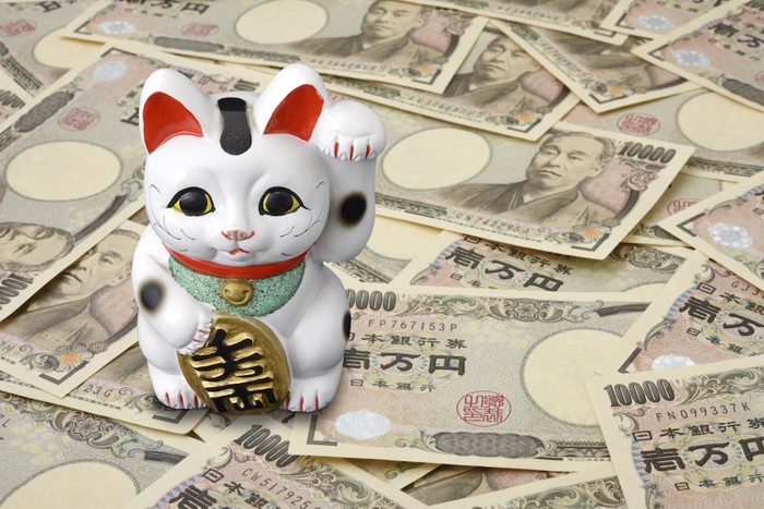 招き猫の下に置かれたお金